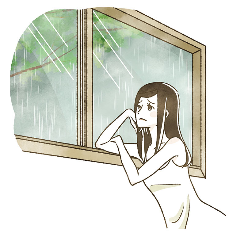 雨の様子を見ながら体調の悪い女性