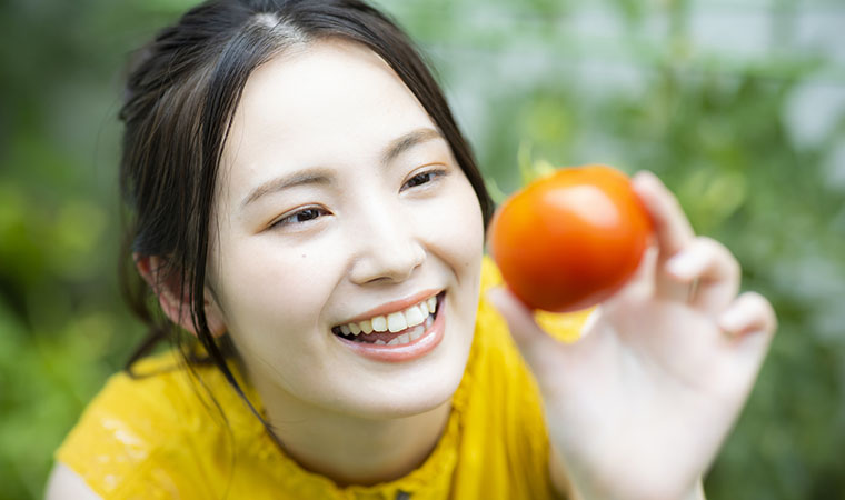 トマトを持つ女性