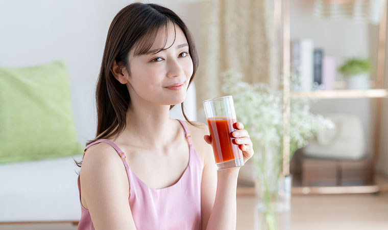 トマトジュースを飲む女性