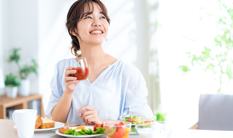 トマトジュースを飲む女性