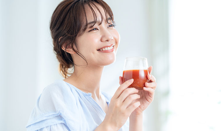 トマトジュースを飲む女性