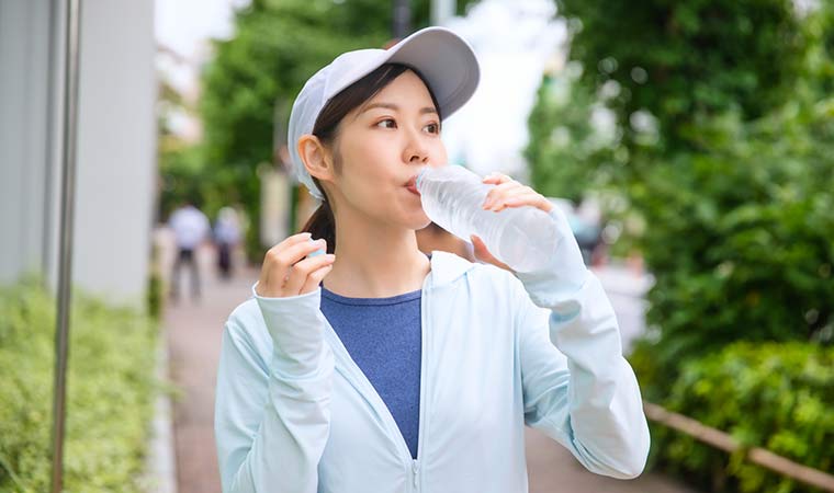 水で水分補給する女性