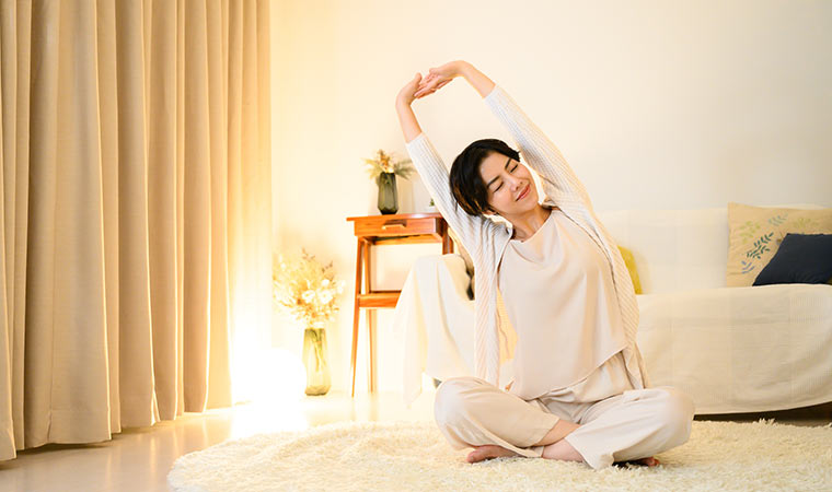 部屋でストレッチをしている女性