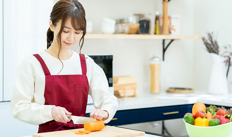 にんじんを切る女性