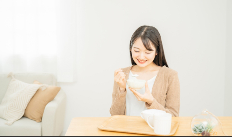 ヨーグルトを食べる女性