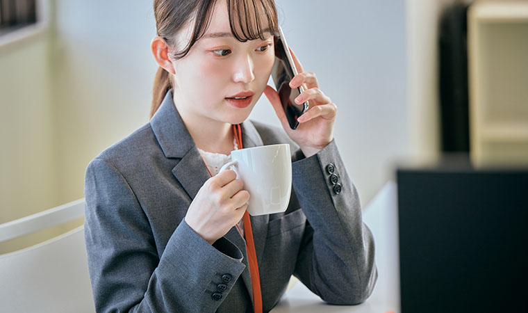 コーヒーを飲む仕事中の女性