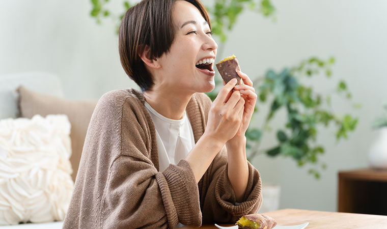 焼き芋を食べる女性