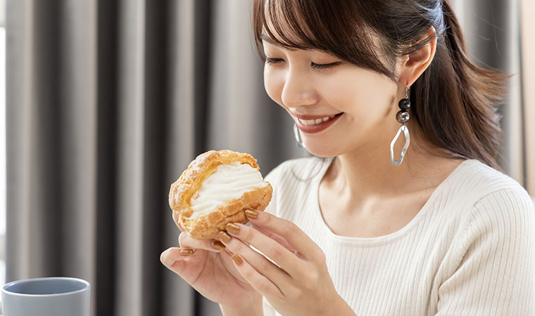 シュークリームを食べる女性